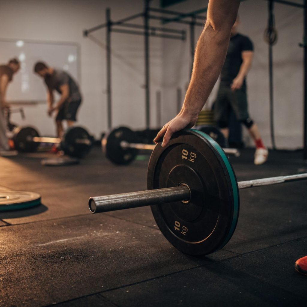 Personne en train de soulever des poids lors d'un entraînement de musculation.